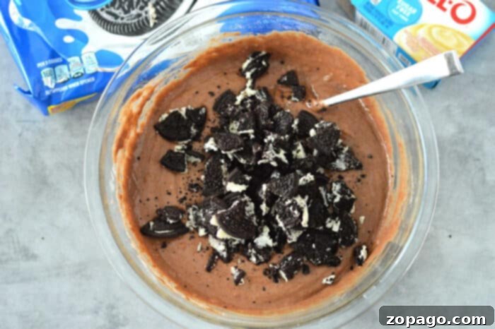 Cookies and Cream Bundt Delight 4 Crushed Oreos mixed into cake batter in a bowl, ready for baking.