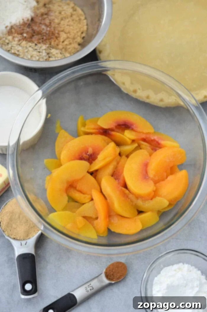 Pantry Peach Pie 3 Unbaked peach pie filling with fresh peach slices and a crumb topping, ready for the oven.