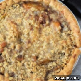 Pantry Peach Pie 5 A freshly baked canned peach pie with a crumbly oat topping sits enticingly next to an ice cream scooper.