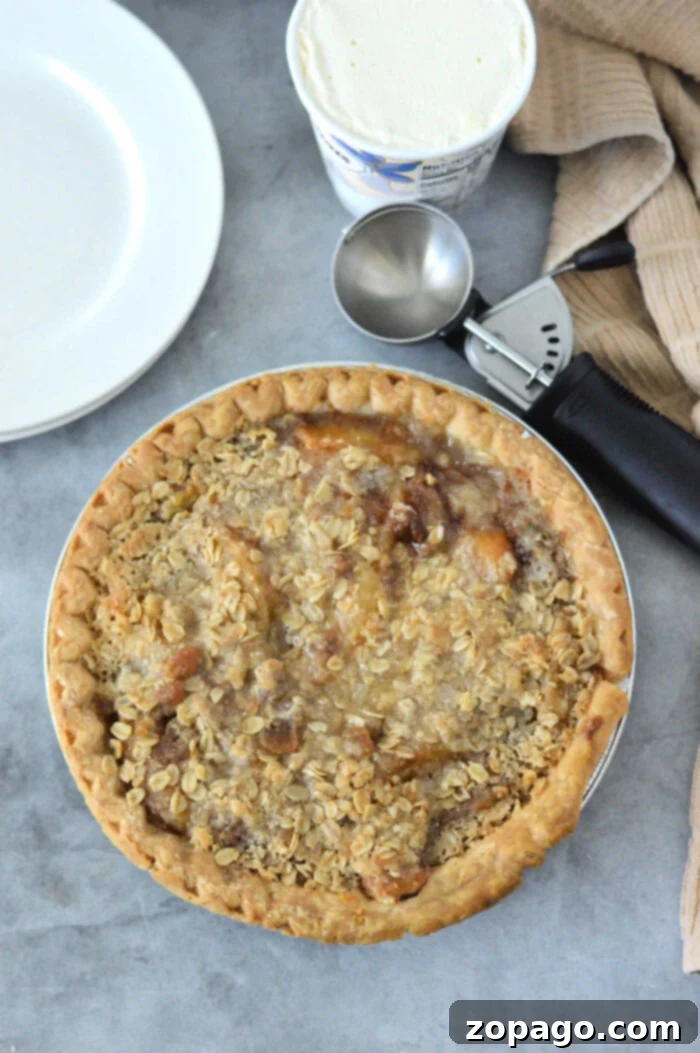 Pantry Peach Pie 7 A deliciously baked peach cobbler with a scoop of vanilla ice cream, ready to be served.