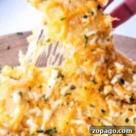 Close-up of a hand pulling a cheesy, herb-topped Little Caesars Cheese Breadstick with melted cheese stretching.