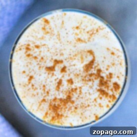 Spiced Pumpkin Cold Foam 8 Top view of a creamy drink in a glass, sprinkled with cinnamon, infused with pumpkin cream cold foam.