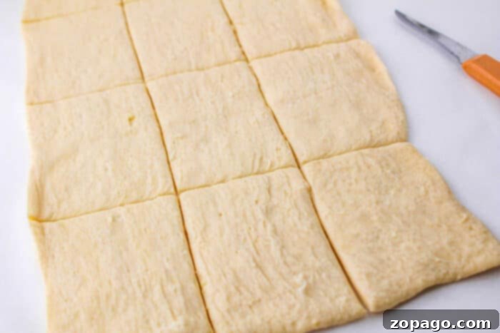 Crispy Buffalo Chicken Rolls 3 Sheets of crescent dough neatly cut into rectangular pieces, ready for filling.