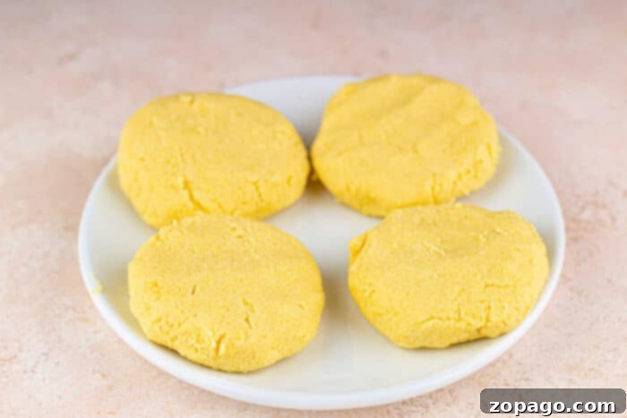 Crispy Cornbread Cakes 3 Cooking cornbread patties in a hot pan with oil
