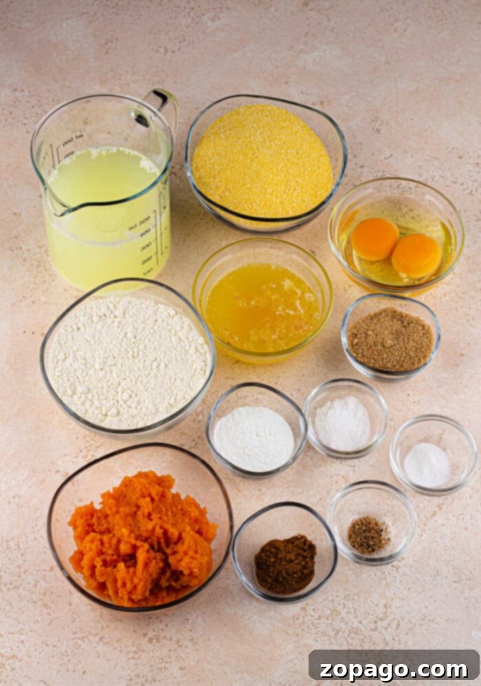 Southern Sweet Potato Cornbread 3 Various baking ingredients, including flour, eggs, mashed sweet potatoes, cornmeal, and spices, are arranged in small bowls, ready for mixing.