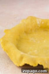 Buttery Shortbread Pie Crust 9 A shortbread pie crust rests in a fluted-edge pie pan on a light countertop, ready for your favorite filling.