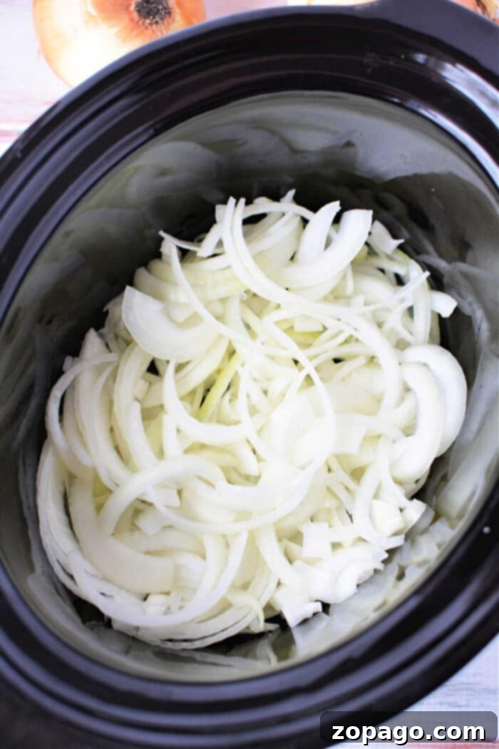 Slow Cooker Onion Gold 8 Caramelize Onions in Slow Cooker - a close up of the cooked, golden caramelized onions with a spoon.