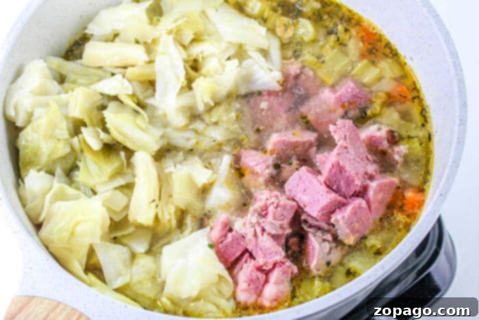 Hearty Corned Beef and Cabbage Bowl 5 A cutting board with diced corned beef and fresh cabbage, ready for soup preparation