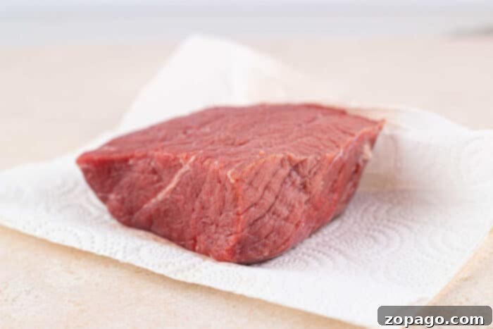 Tender Bottom Round Roast Made Easy 4 Oven Baked Bottom Round Roast resting on a cutting board, recently removed from the oven.