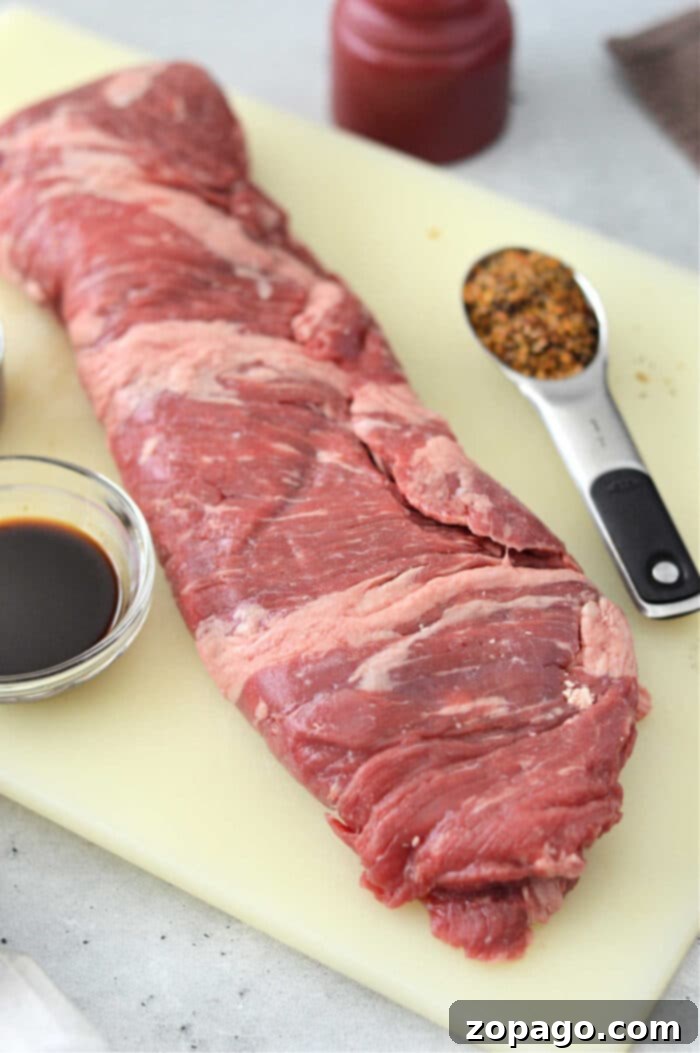 Perfect Oven Skirt Steak Recipe 3 A raw skirt steak rests on the cutting board, ready to become a masterpiece. Alongside it, a bowl of rich soy sauce and a spoonful of spices await their turn to enhance flavors. Imagine preparing skirt steak in the oven with this selection for an unforgettable culinary experience.
