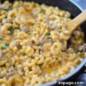 Creamy Cheesy Beef and Pasta Skillet 6 Macaroni and cheese with ground meat in a skillet, topped with herbs and stirred with a wooden spoon, brings the cozy comfort of Velveeta together with the convenience of Hamburger Helper.