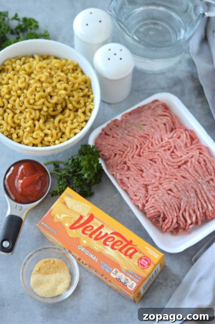 Creamy Cheesy Beef and Pasta Skillet 8 Hamburger Helper from scratch: A rustic close-up showing the texture of the cheesy macaroni and ground beef in a dark skillet, with a wooden spoon.