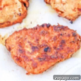 Three pieces of crispy fried chicken rest on paper towels, boasting a perfectly golden-brown crust—a testament to mastering how long to deep fry chicken breast for that ideal crunch.