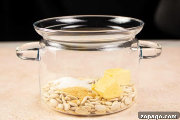 From Dry to Delicious Butter Beans 4 A glass pot with butter beans, butter, sugar, and spices inside rests on a light surface. Its reminiscent of preparing a comforting dish like butter beans—simple yet satisfying in its blend of ingredients.