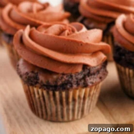 Effortless Brownie Cupcakes 7 Brownie cupcakes with swirled frosting are artfully arranged on a wooden board, creating an irresistible treat.