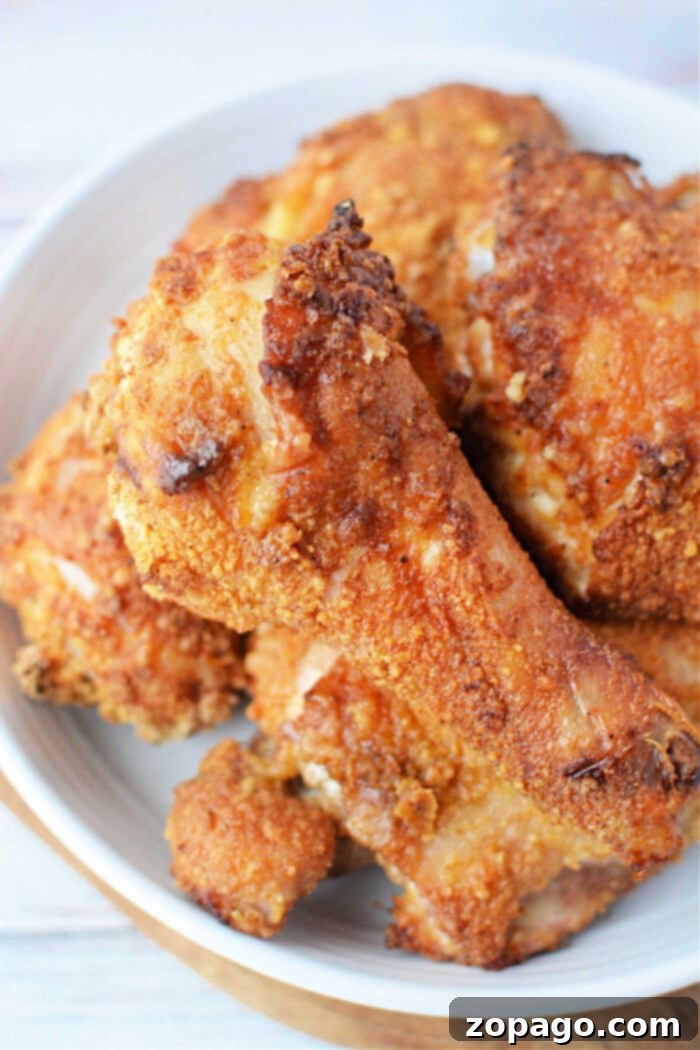 Crispy Baked Bisquick Chicken 2 A plate of golden-brown Bisquick oven-fried chicken drumsticks and thighs, perfectly crispy and ready to serve.