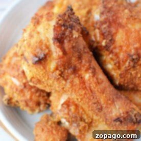 A plate of golden-brown Bisquick oven-fried chicken drumsticks and thighs.