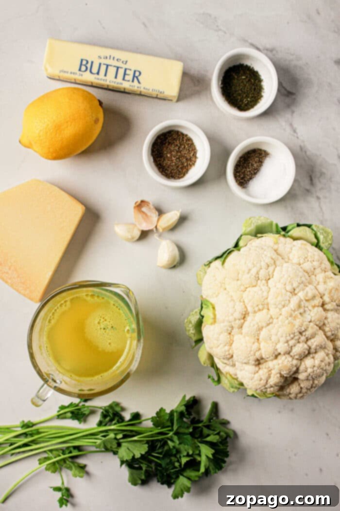 Perfect Slow Cooker Whole Cauliflower 3 Ingredients on a marble surface: butter, lemon, cheese, garlic, whole cauliflower, herbs, broth in a jug, and small spice bowls. Perfect for creating a delightful cauliflower recipe that can easily be adapted for Crock Pot cooking.