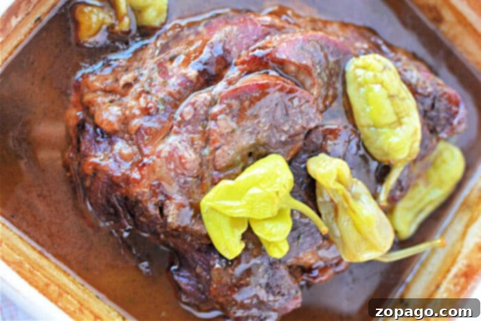 Slow Cooker Mississippi Pot Roast 6 Enjoy a delightful Mississippi Pot Roast featuring juicy roast beef in brown sauce, topped with vibrant green pepperoncini peppers.