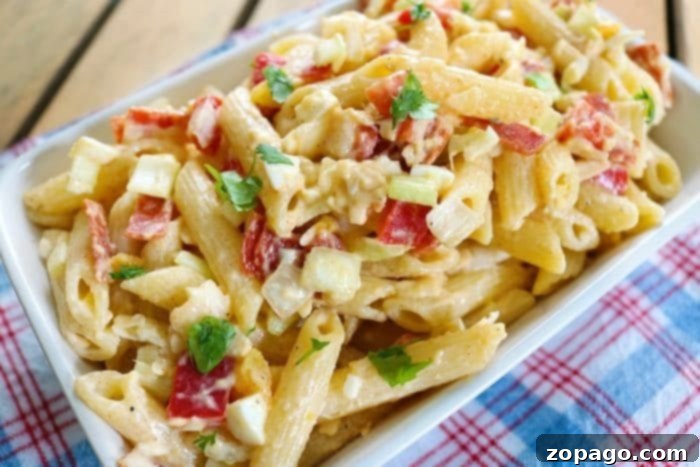 Creamy pasta salad that's a great side dish for any bbq or potluck. Simple creamy parmesan pasta salad recipe you can load up with anything. #pasta #salad #easy #creamy Large bowl of creamy pasta salad with mixed vegetables and herbs, ready to serve.