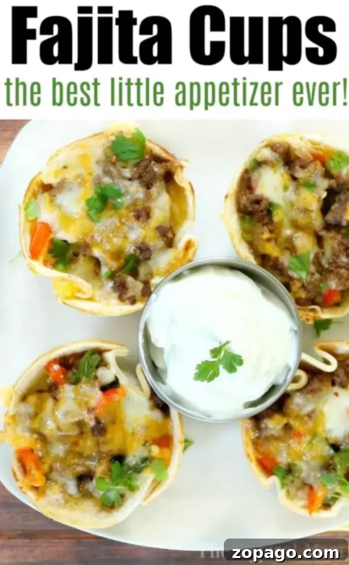 Fajita cups are the perfect appetizer. #steak #beef #appetizer #fajita #fajitas Top-down view of four tortilla cups brimming with juicy steak fajita mix, featuring cooked beef, vibrant red and green bell peppers, and gooey melted cheese on a white plate. A small bowl of sour cream crowned with cilantro sits in the center. Text at the top reads Fajita Cups.