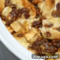 Overnight Crockpot French Toast Casserole 2 Close-up of a perfectly baked Crockpot French toast casserole, transformed into a delightful bread pudding with golden pecans and rich caramel sauce.