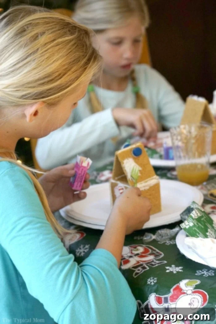 Free Christmas Fun Checklist for Kids 3 Family decorating gingerbread houses together