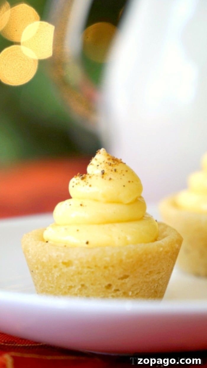 Egg nog cookie cups are so fun! Make them any flavor you want, but this is a great Christmas dessert that is easy to do and the kids love them! Delicious egg nog cookie cups with creamy filling, topped with nutmeg, on a festive holiday platter