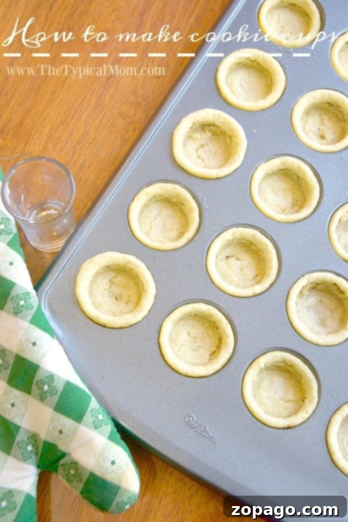 How to make cookie cups! Make them any flavor you want, but this is a great dessert that is easy to do and the kids love them! Hands pressing a shot glass into warm baked cookie dough in a mini muffin tin to create a cup shape
