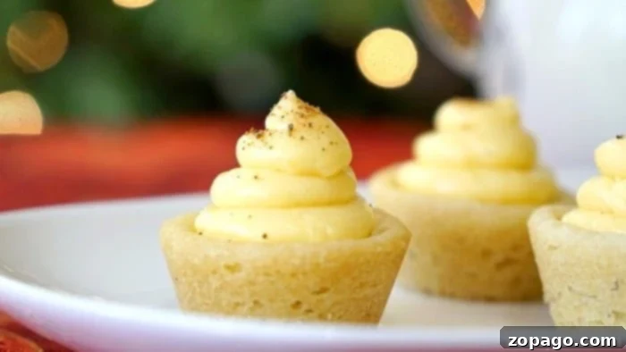Festive Eggnog Cookie Cups 3 Freshly baked mini egg nog cookie cups ready to be filled, with some already filled and garnished