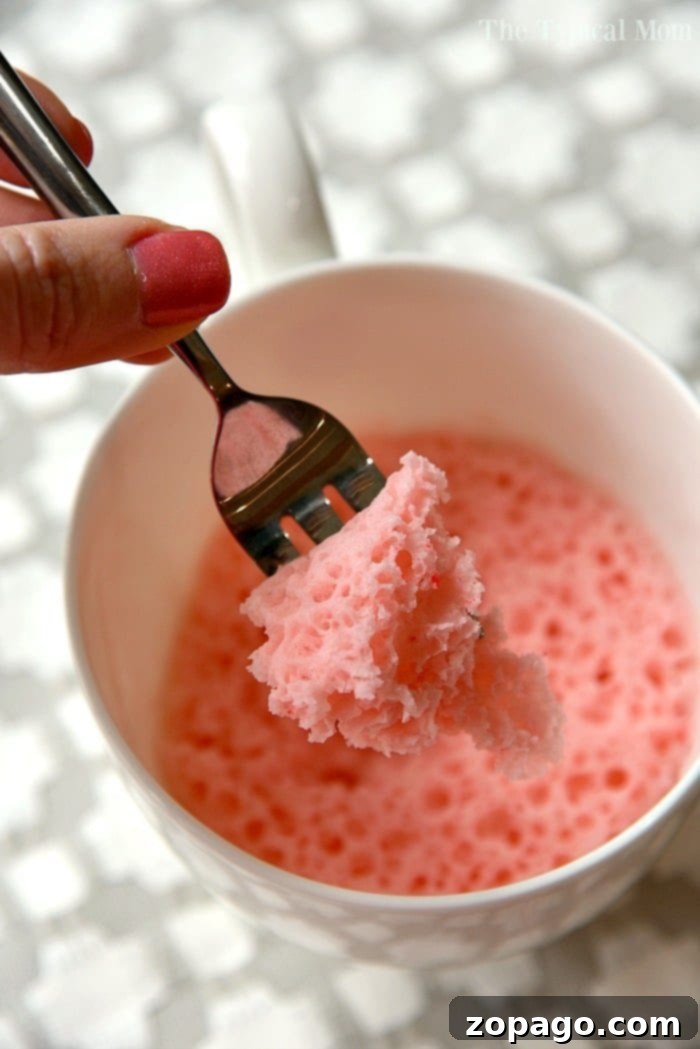 Strawberry cake in a mug recipe that uses just 3 ingredients and takes just 1 minute in the microwave! So moist, it's the perfect dessert for one! #mugcake #cake #microwave #dessert #strawberry #angelfoodcake A freshly made strawberry mug cake, showing its moist and tender interior.