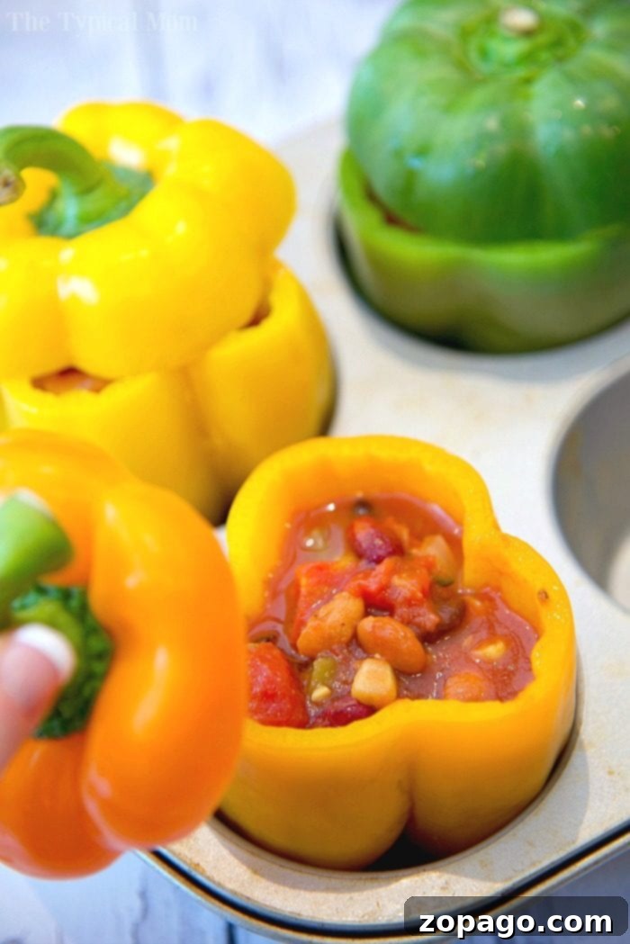 Hearty Chili Stuffed Bell Peppers: An ideal healthy dinner that’s simple to make and loved by all. Close-up of baked chili stuffed bell peppers, garnished with cheese and ready to serve.