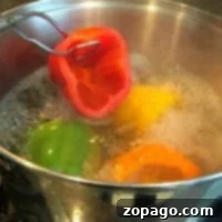 A pot of water bubbles away as tender bell peppers simmer, while a vibrant red pepper is carefully lifted out with tongs. This scene sets the stage for a delicious stuffed green peppers recipe waiting to delight your taste buds.