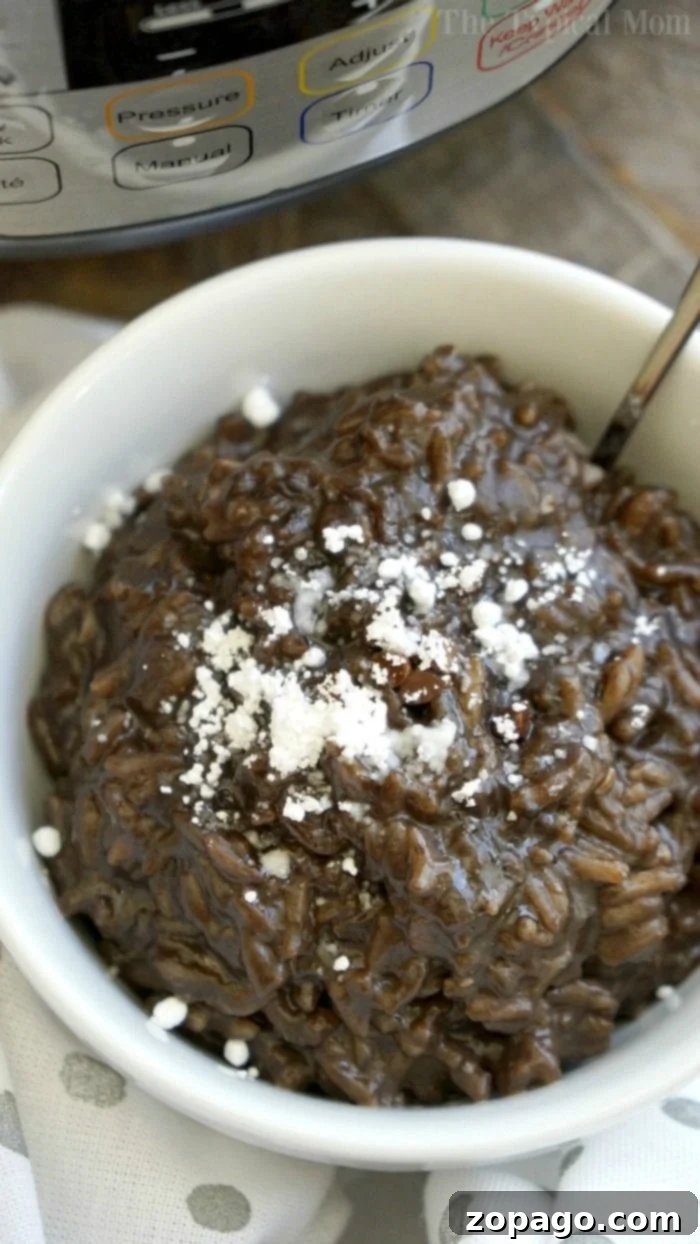 Instant Pot chocolate rice pudding is the most amazing pressure cooker dessert you will ever make. It's quick, smooth, and full of chocolate! Close-up of Instant Pot chocolate rice pudding in a bowl, garnished with chocolate shavings.