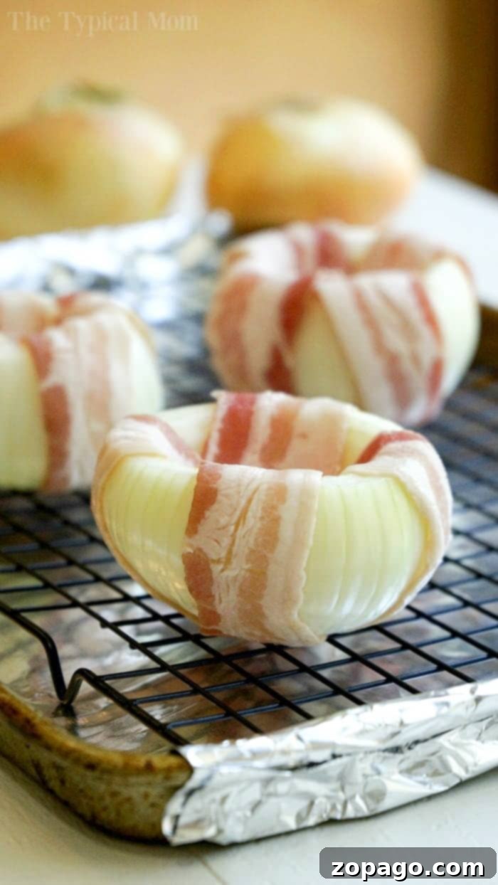 Irresistible Stuffed Onions: Baked or Grilled Perfection Close-up of perfectly cooked mozzarella-stuffed, bacon-wrapped onions, showcasing golden-brown cheese and crispy bacon edges.