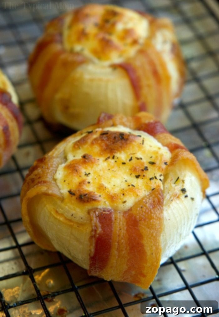 Freshly Baked Mozzarella Stuffed Bacon Wrapped Onions Golden-brown, bubbly mozzarella-stuffed bacon-wrapped onions, fresh out of the oven, ready to be enjoyed.