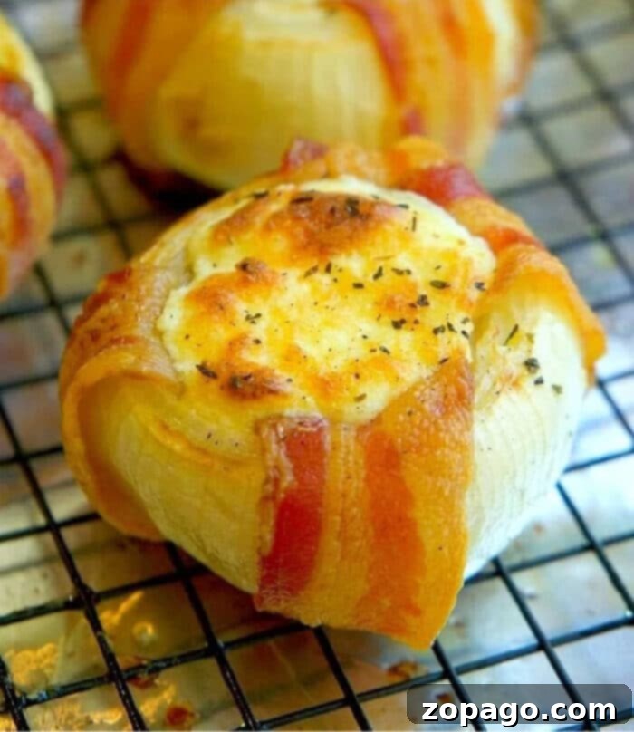 Single Mozzarella Stuffed Onion, Ready to Eat A close-up shot of a single mozzarella-stuffed onion, perfectly browned with melted cheese and crispy bacon edges.