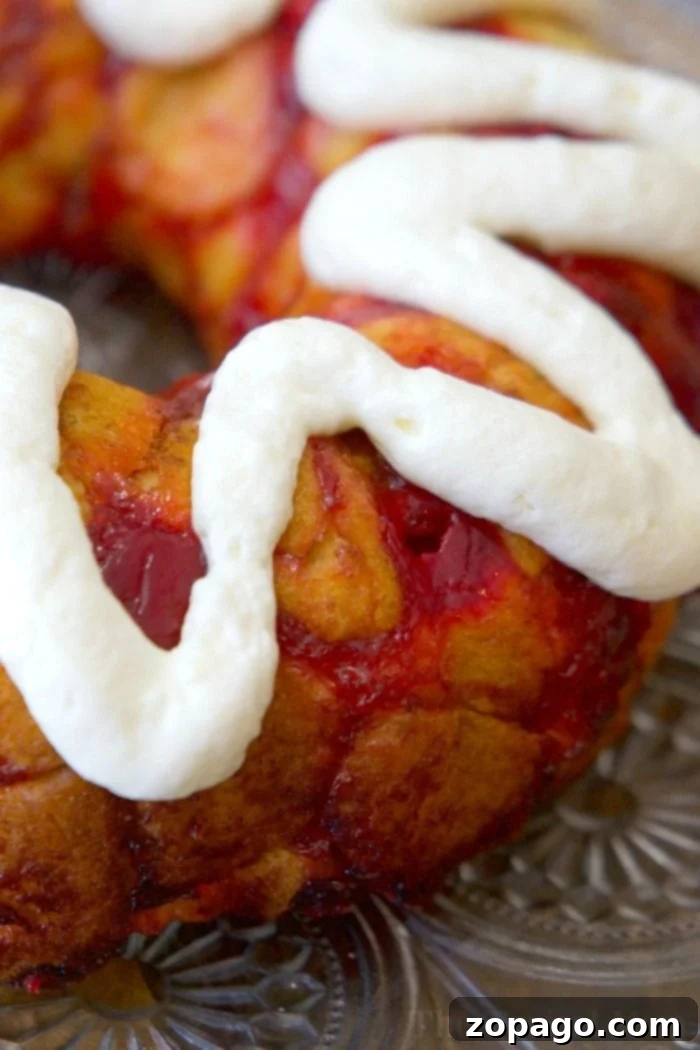 This cherry cheesecake monkey bread is incredibly easy to make with refrigerated biscuits and boasts an amazing flavor profile. It's the perfect treat for breakfast or dessert, offering a simple bundt cake solution for any gathering. Customize your monkey bread at home using your favorite pie filling, such as luscious cherry or vibrant blueberry! #monkeybread #cherrycheesecakemonkeybread #cinnamonrollmonkeybread #easyrecipe #quickdessert #breakfastbundt #fruitfilled #homemade #bundtcake #refrigeratedbiscuits cherry cheesecake monkey bread