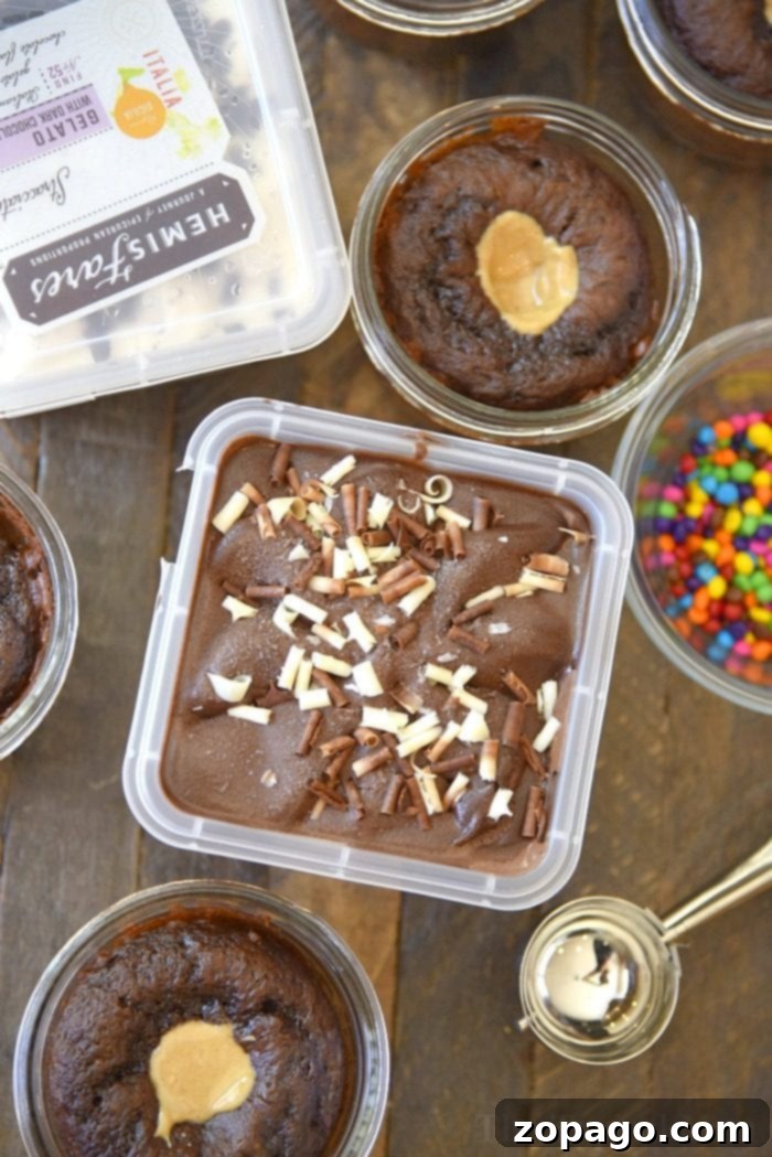 You have got to try these 4 ingredient peanut butter filled cupcakes in a jar!! They are ooey and gooey topped with chocolate gelato and are a little jar full of Heaven. Served in mini mason jar they're a fun dessert for one that everyone will rave over and ask you for the recipe. #masonjar #dessert #cupcakes #inajar #birthday #peanutbutter Close-up of a peanut butter filled cupcake in a jar, topped with melted chocolate gelato and a sprinkle of chocolate chips
