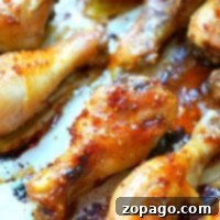 Close-up of baked teriyaki chicken drumsticks glazed with a sticky sauce, arranged on a baking tray.