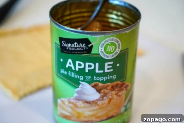 Cinnamon Roll Waffles 2 A opened can of apple pie filling, showing delicious sliced apples in a sweet, gooey sauce. This is a key ingredient for making stuffed apple pie cinnamon roll waffles.