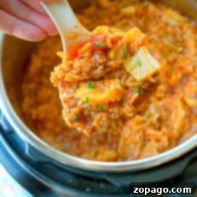 A spoonful of instant pot stuffed cabbage casserole being lifted from an Instant Pot.