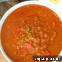 Quick Instant Pot Spaghetti Sauce 4 A bowl of hearty spaghetti sauce garnished with herbs sits next to an Instant Pot, ready to whip up a delicious spaghetti sauce, all on a rustic wooden surface.