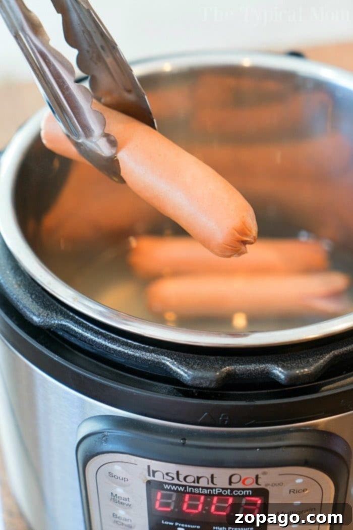 Instant Pot hot dogs are a fantastic, cheap, and easy dinner option for any season. Whether it's a summer potluck, a picnic, or a busy weeknight, these kid-friendly favorites become plump and juicy in minutes, ready for all your favorite fixings. This guide covers cooking times for both cased and traditional hot dogs. Instant Pot Hot Dogs ready to be served, showing perfectly plump wieners in a pressure cooker. A quick and easy meal solution.