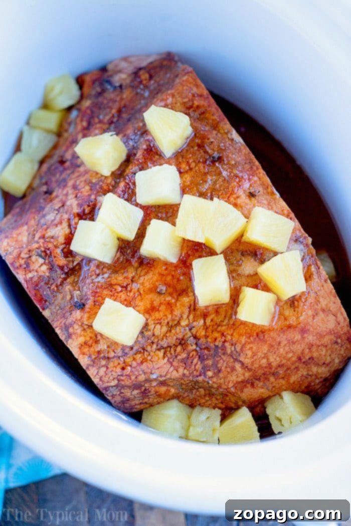This pineapple crockpot ham recipe is sweet, tender, and delicious. Cooks on it's own in your slow cooker and is ready when you are, perfect for holidays! #crockpot #slowcooker #ham #pineapple #christmas #dinner #easter crockpot ham