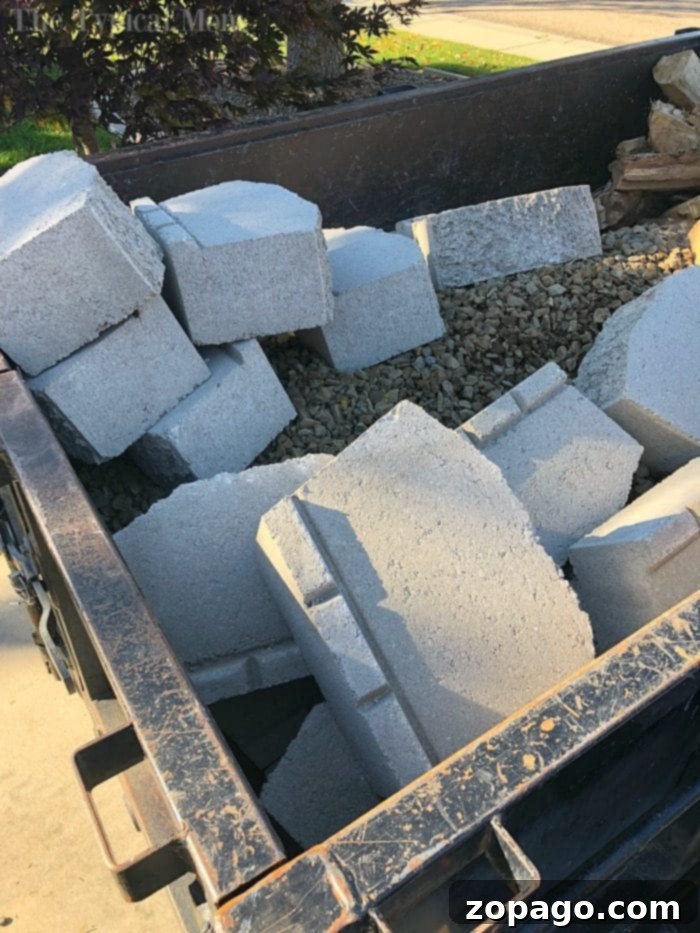 Finished affordable fire pit, ready for use and enjoyment in a residential backyard. Completed DIY backyard fire pit project with stone walls and surrounding area.