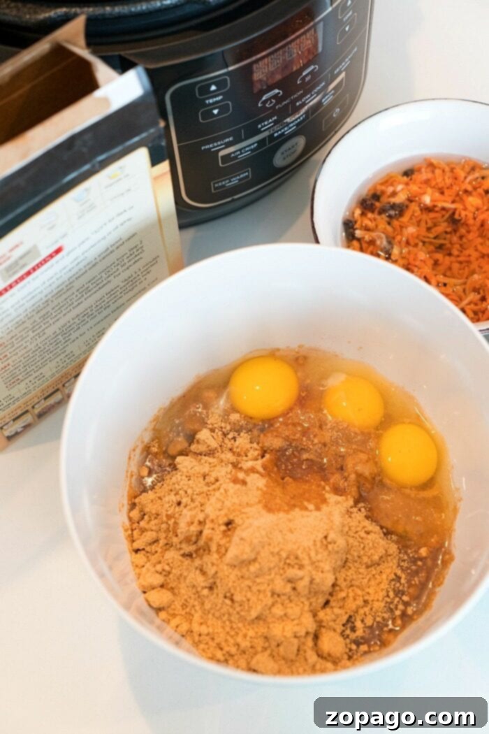 Bake Irresistible Ninja Foodi Cakes 4 A bowl with eggs and brown mix sits alongside a Ninja Foodi cake, with an Instant Pot and various ingredients scattered in the background on a kitchen counter.