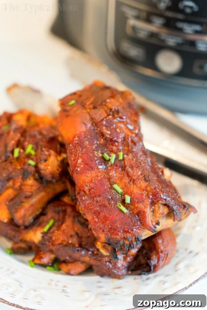 Close-up of delectable Ninja Foodi ribs, featuring a beautiful caramelized barbecue sauce and melt-in-your-mouth tenderness. A close-up of Ninja Foodi ribs, highlighting the caramelized barbecue sauce and tender meat.