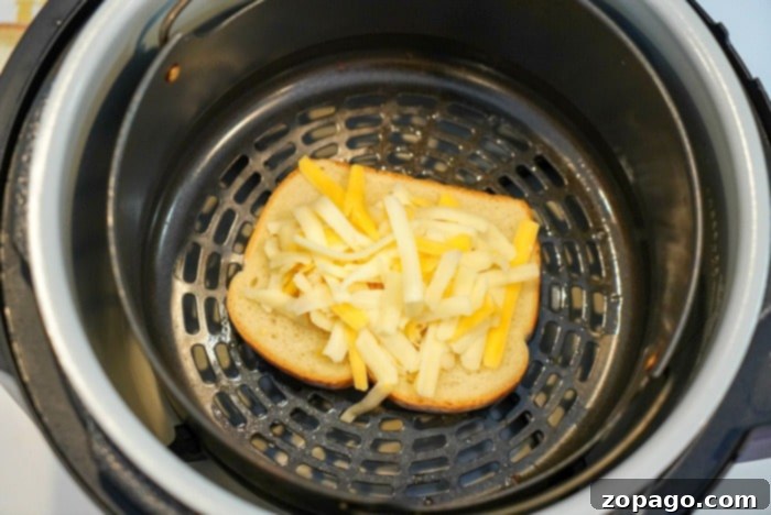 Air Fryer Grilled Cheese Perfection 8 Two air-fried grilled cheese sandwiches sliced in half, revealing melted cheese, served with a side of crispy green pickles.