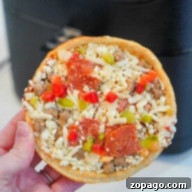 Perfect Air Fryer Frozen Pizza Every Time 8 A small, round frozen pizza, topped with various ingredients, ready to be cooked in an air fryer.